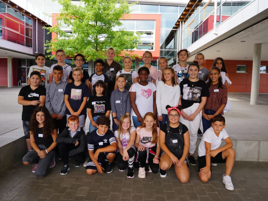 Klassenfoto einer neuen fünften Klasse im Schulhof.